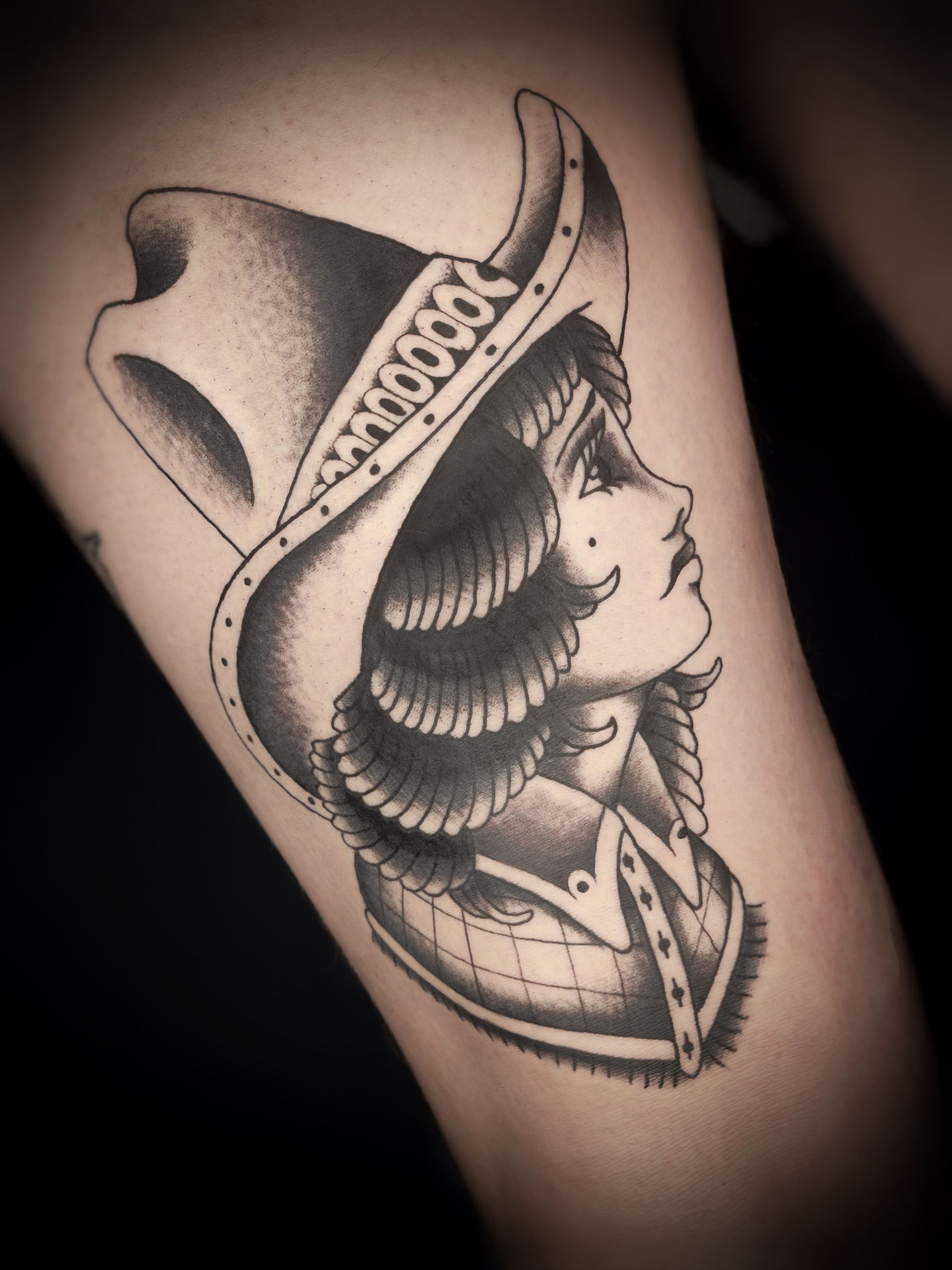 Traditional american tattoo of face of girl with cowboy hat in black and grey