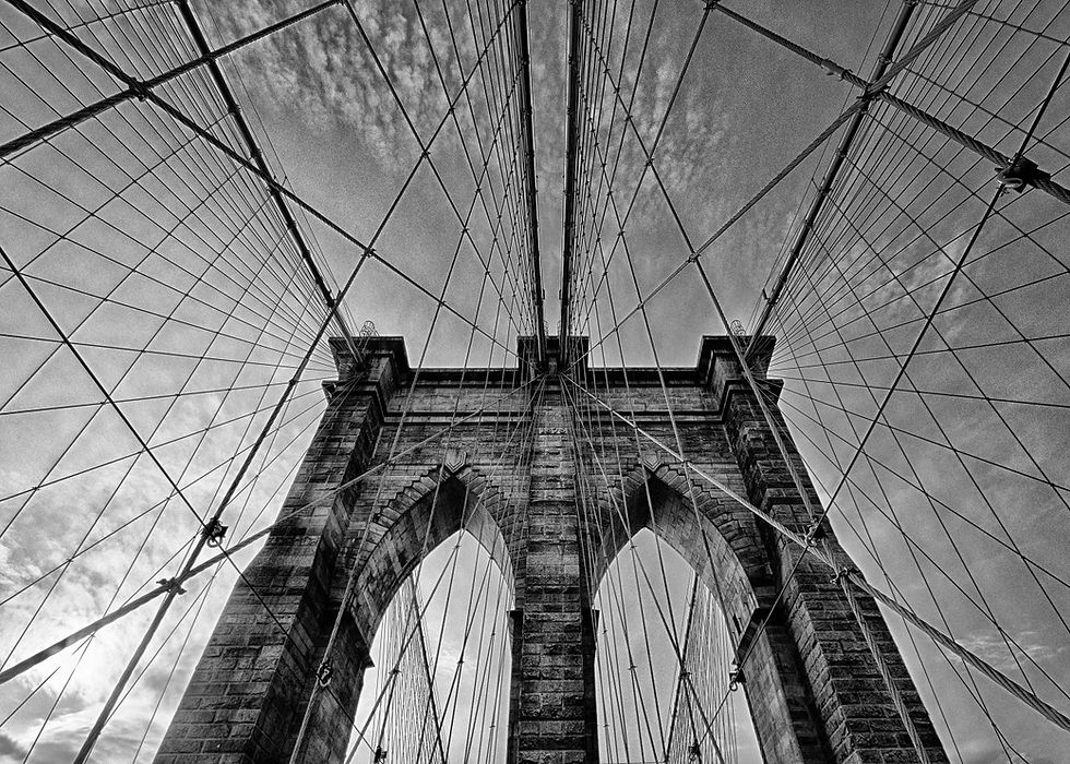 Low angle view of Brooklyn Bridge stone tower and cables