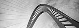 Black and white low angle view of a modern arched bridge