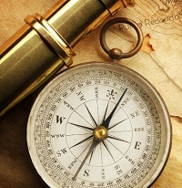 Vintage compass and brass telescope on an old map.