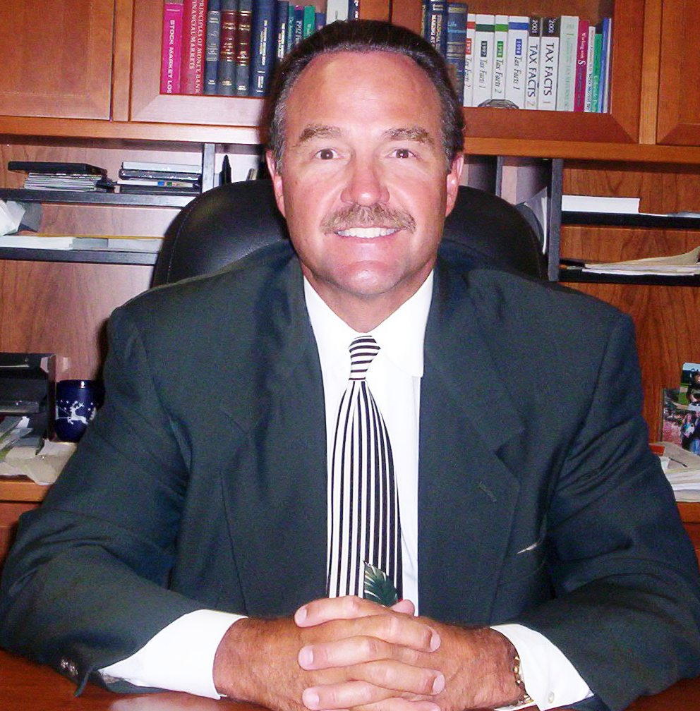 Professional man in a suit smiling at his desk