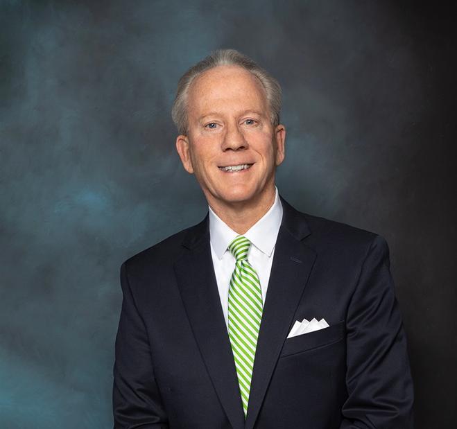 Smiling businessman in a suit with a green striped tie.