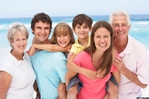 Multi-generational family smiling on a beach