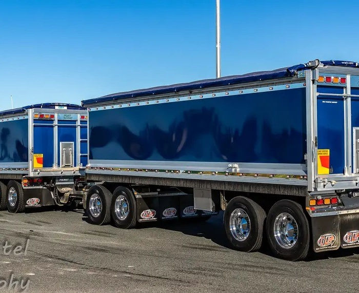 Blue semi-truck with two tipper trailers