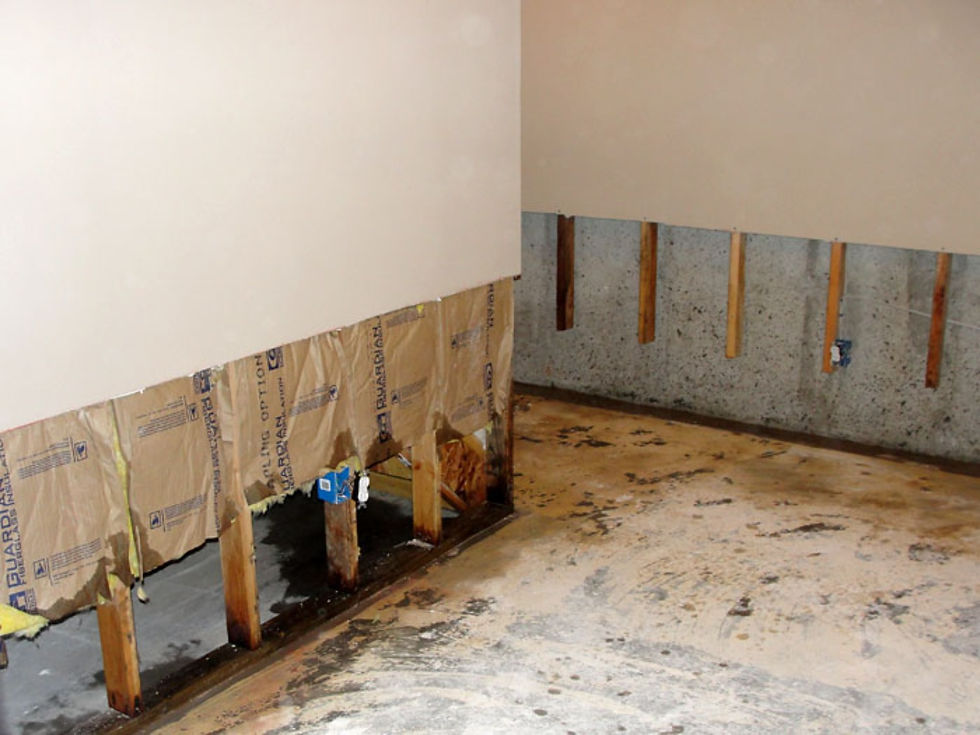 water damaged drywall removed exposing wall studs and framing after leak