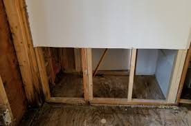 Drywall cut open for plumbing repair with exposed pipes and wall openings