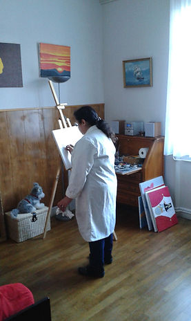 Aline Pouget peignant dans son atelier devant son chevalet