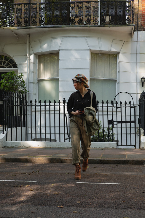 London style blogger in a black shirt, green cargo pants, beret, heeled combat boots | RollingBear Travels