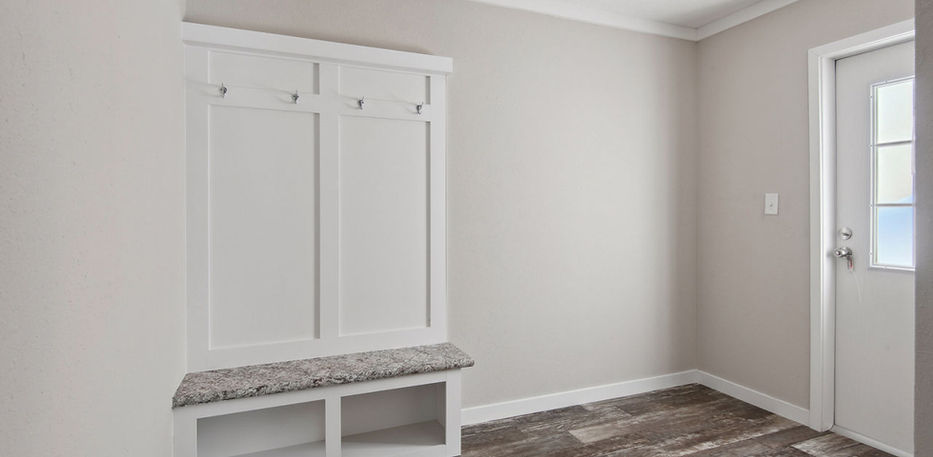 Modern white mudroom bench with hooks and storage bins.