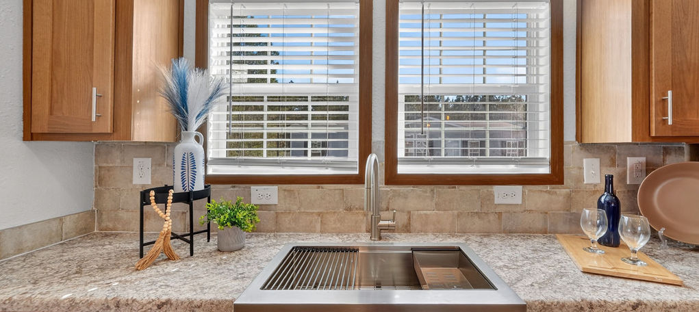 Modern kitchen with farmhouse sink and granite countertops.