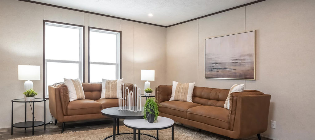 Modern living room with brown sofas, coffee tables, and art.