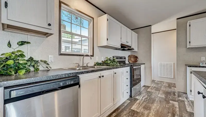 Kitchen with white cabinets, dark counters, stainless steel appliances