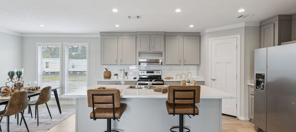 Modern kitchen with white island and brown barstools