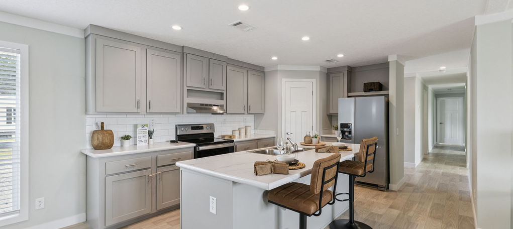 Modern kitchen with grey cabinets and white island at The Mill Creek
