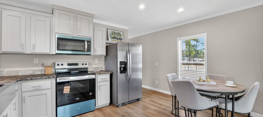 Modern kitchen with white cabinets and dining area