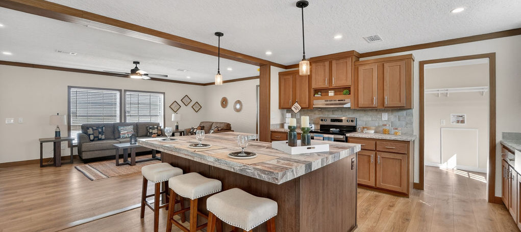 Modern kitchen island with wood cabinets and bar stools.