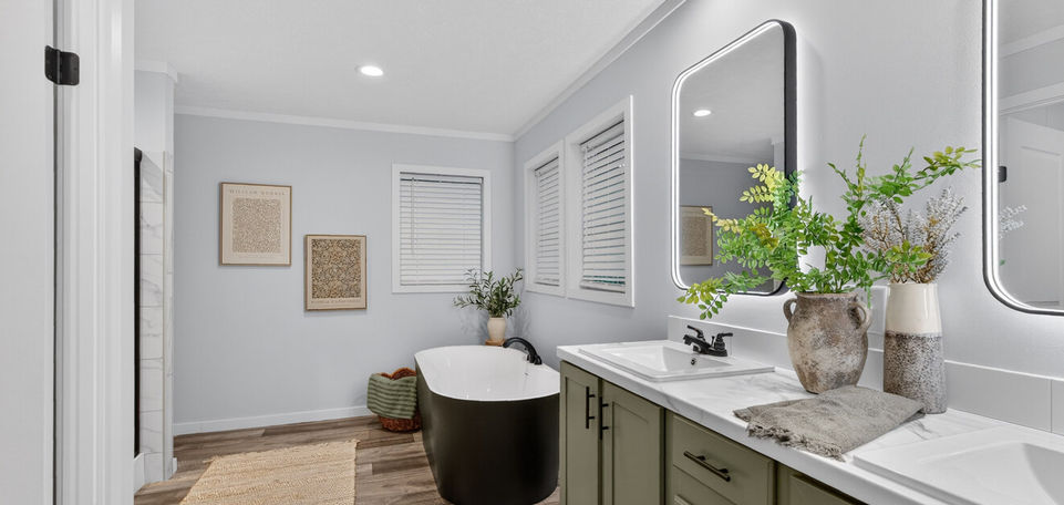 Spacious bathroom with black tub, green vanity, and wood floor