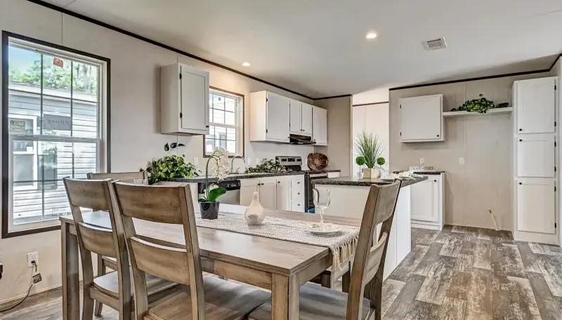 Modern kitchen and dining area with white cabinets and wooden table