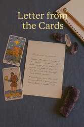 A flat lay of a handwritten letter on textured fabric, flanked by Rider-Waite tarot cards "The Star" and "Two of Wands." Amethyst and clear quartz crystals, a spiral notebook, and a golden pen complete the scene.