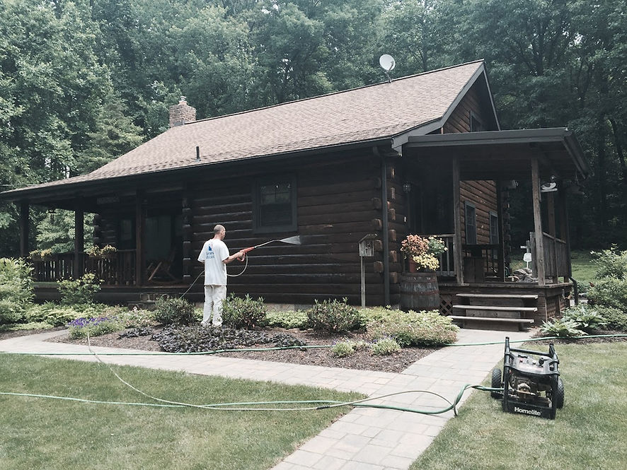 This is a log cabin house that is being pressure washed