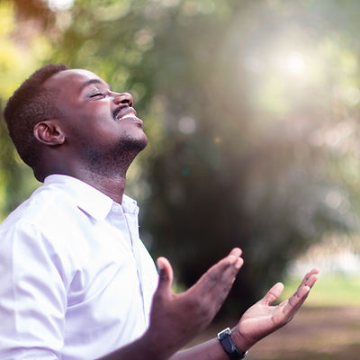 African man praying for thank god with light flare in the green nature.jpg