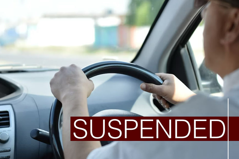 Person driving a car, with hands on the steering wheel. The word "SUSPENDED" is prominently displayed. Bright, blurred background.