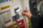 Hand inserting an Uber Mastercard into a gas pump card reader. Labels read Gasoline, with red and yellow color schemes.
