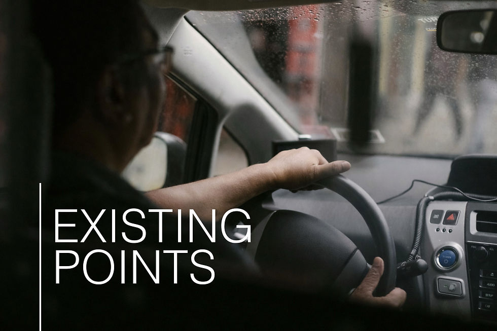 Driver in a car steering through rain with blurred cityscape. Text on image reads "EXISTING POINTS." Mood is focused and calm.