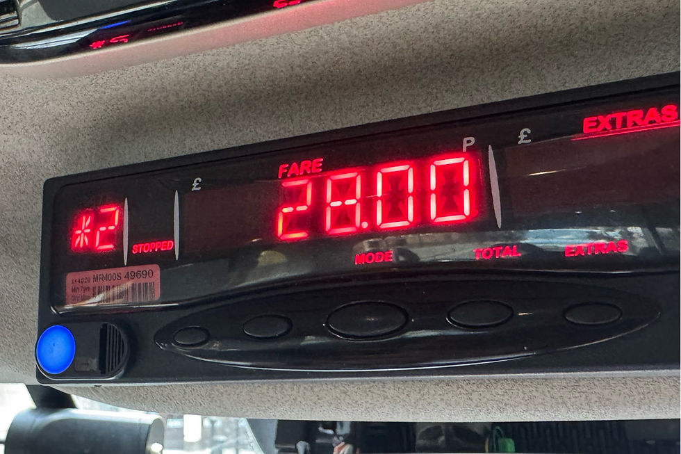 Taxi meter displaying a fare of £28.00, with glowing red digits and a "STOPPED" indicator, set against a light gray interior.