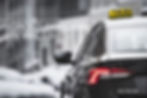 Black taxi on snowy city street with TAXI roof sign; text reads Cross Border in Wales and Octavia.