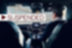 Car interior from backseat, driver visible through front seats. "SUSPENDED" text overlays image with diagonal lines on windows.