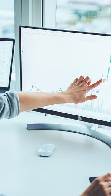 Young female consultant inspecting statistical data on a computer screen