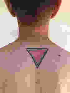 A tattoo of a pink triangle on a man's back