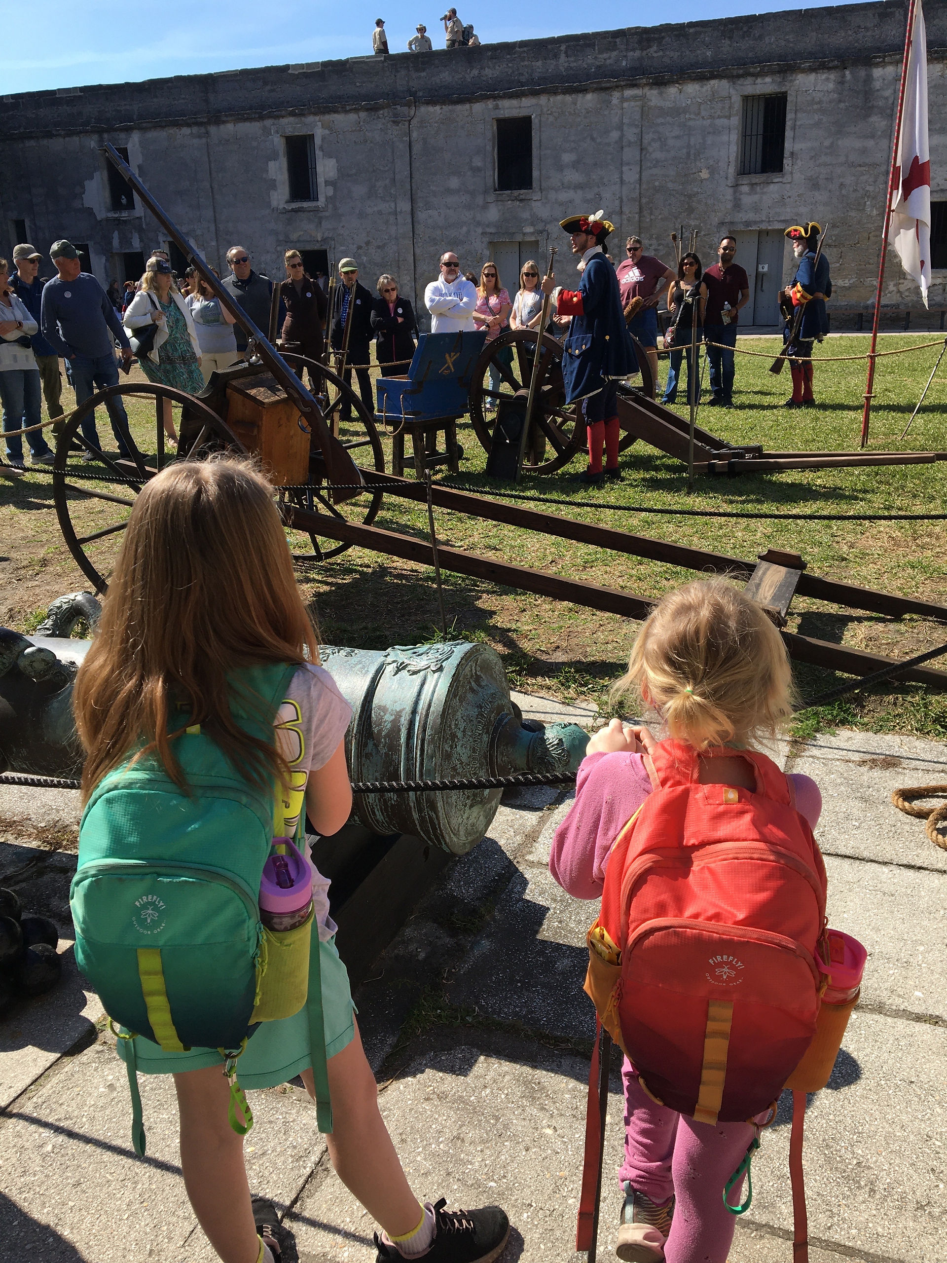 Two little girls watching a history reenactment.