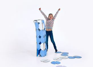 A girl celebrating her structure made of blue noook construction discs.
