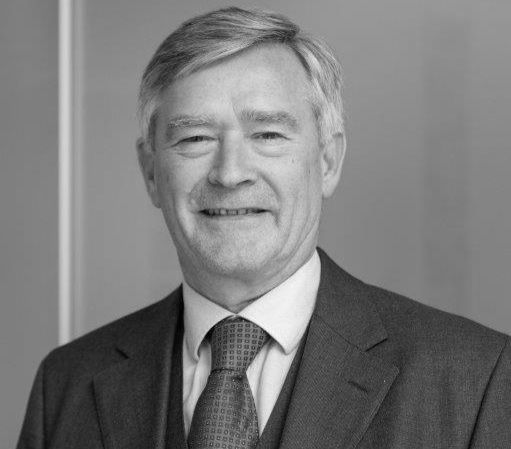 Porträt eines erfahrenen männlichen Rechtsanwalts in Anzug und Krawatte vor neutralem Hintergrund