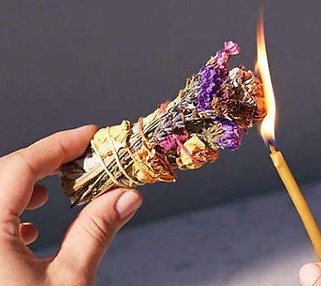 A match being held to a bundle of sage