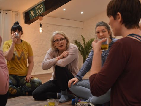 200 hour yoga course participants drinking tea, chatting and laughing in the yoga studio