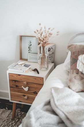 Chambre éco-déco avec table de chevet vintage en bois massif et linge de lit en fibres naturelles pour un sommeil sain.