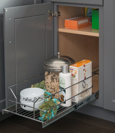 Gray base cabinet with a wire pullout basket slid out, holding dog food, treats, shampoo and a pet bowl
