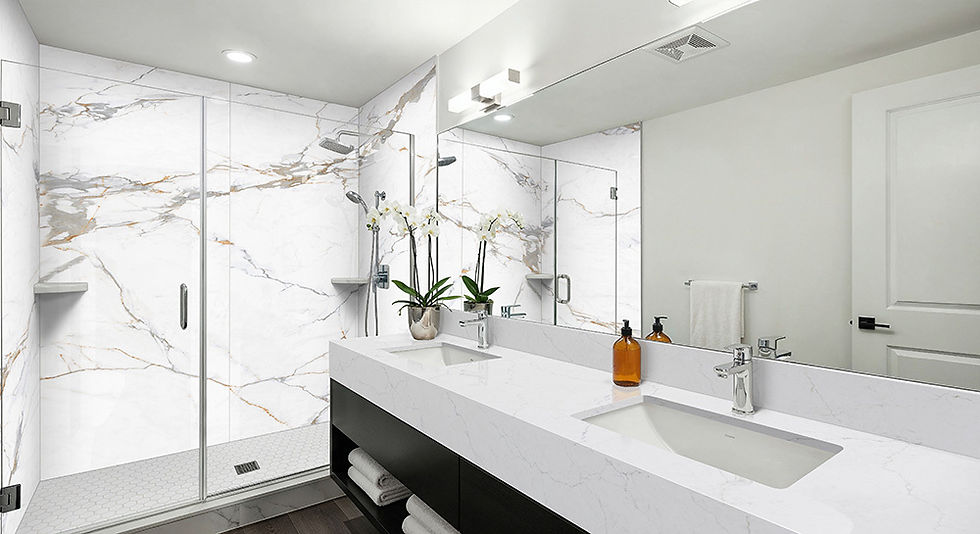 Bathroom with a glass-enclosed shower lined in large white marble-look porcelain slabs with gold veining, a white hexagon mosaic shower floor, and a double vanity with a white countertop