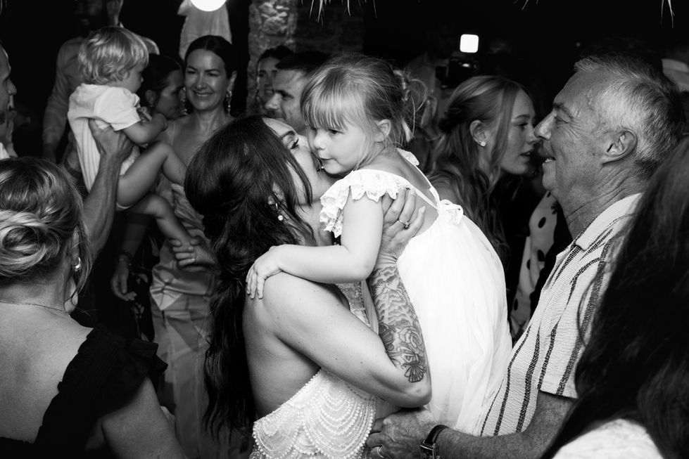 Woman holding a child at a lively gathering in Skiathos.