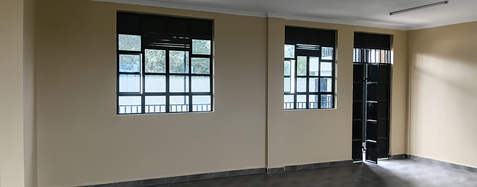 Empty finished classroom with painted walls, smooth floor, and large glazed windows