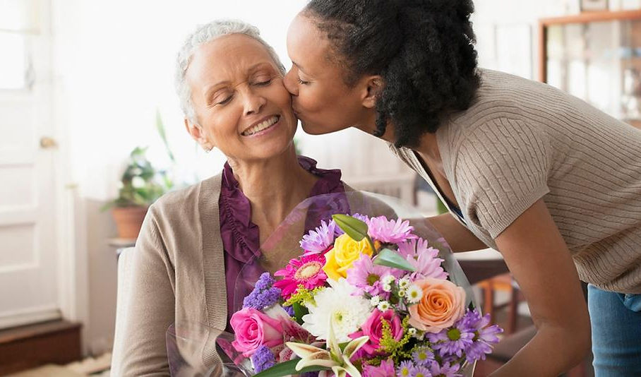woman-bringing-flowers-to-older-woman.jpg