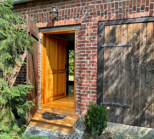 Holztür und Scheunentor an Ziegelgebäude