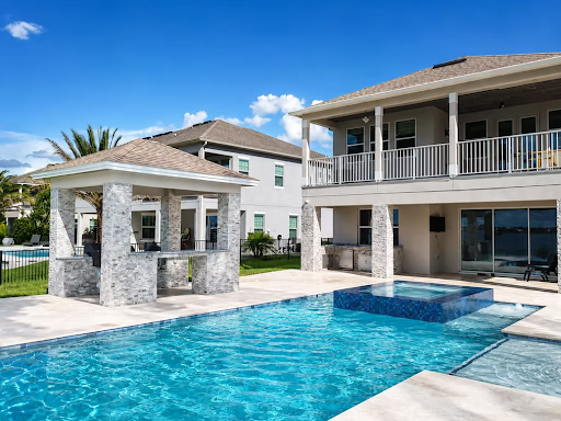 Luxury backyard pool with modern pool cabana and two-story home.
