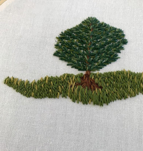 Hand-embroidered tree with textured green leaves and grass on white fabric, crafted by Happy Sheep Creation