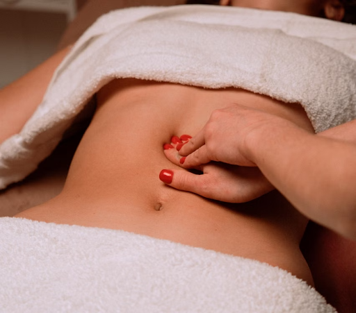 Close-up of a client receiving a gentle abdominal massage treatment at Le Chalan Nail Spa.