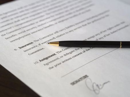 Close-up of insurance contract document with pen, highlighting policy terms and coverage details.