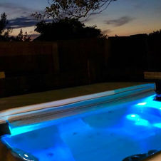 An image of our hot tub spa area in the evening at Norfolk Beach House.